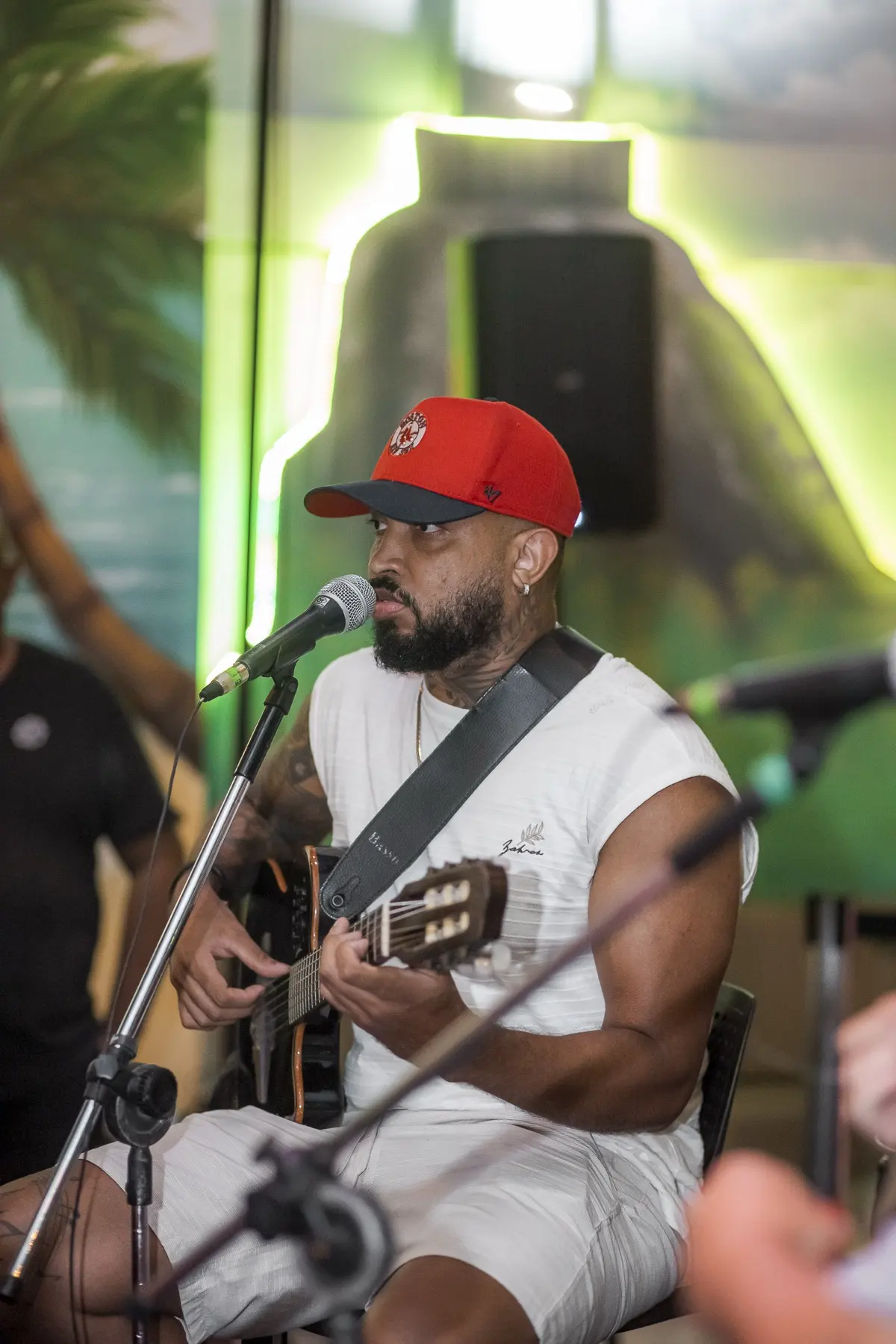 Músico cantando e tocando cavaquinho no Quintal do Samba