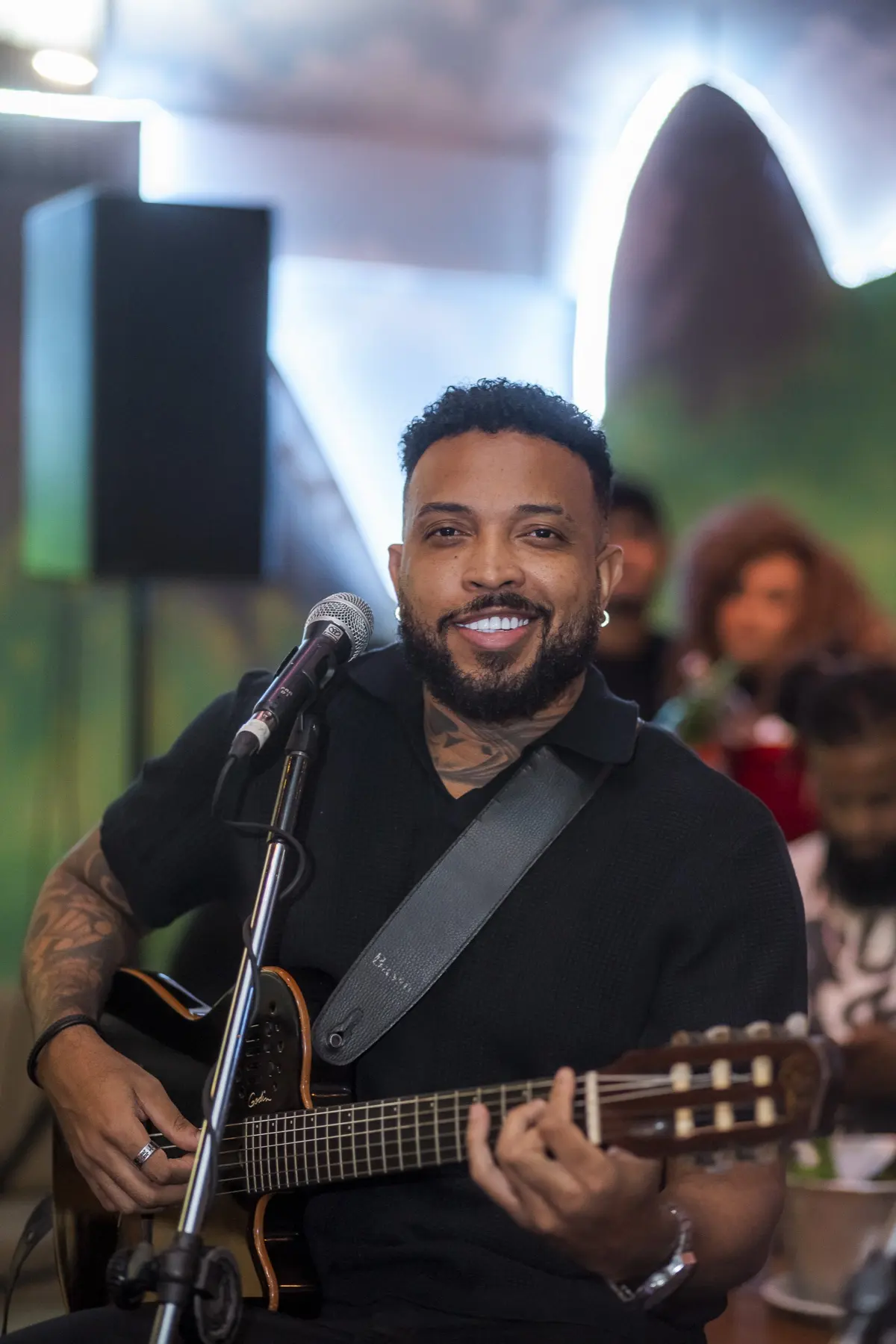 Músico do Nossas Terças cantando e tocando violão numa terça no Quintal do Samba